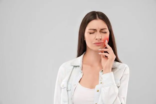 Woman experiencing toothache and holding her cheek due to dental pain