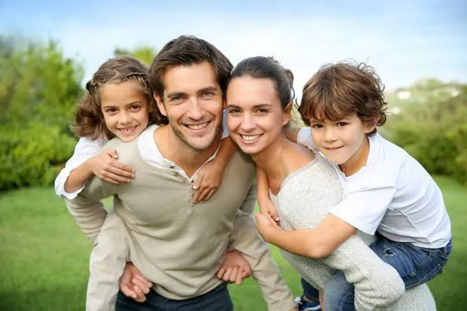 Happy family smiling together and showcasing healthy, confident smiles