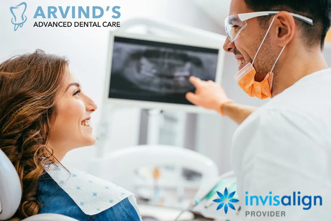 Dentist explaining a dental X-ray to a smiling patient during a consultation