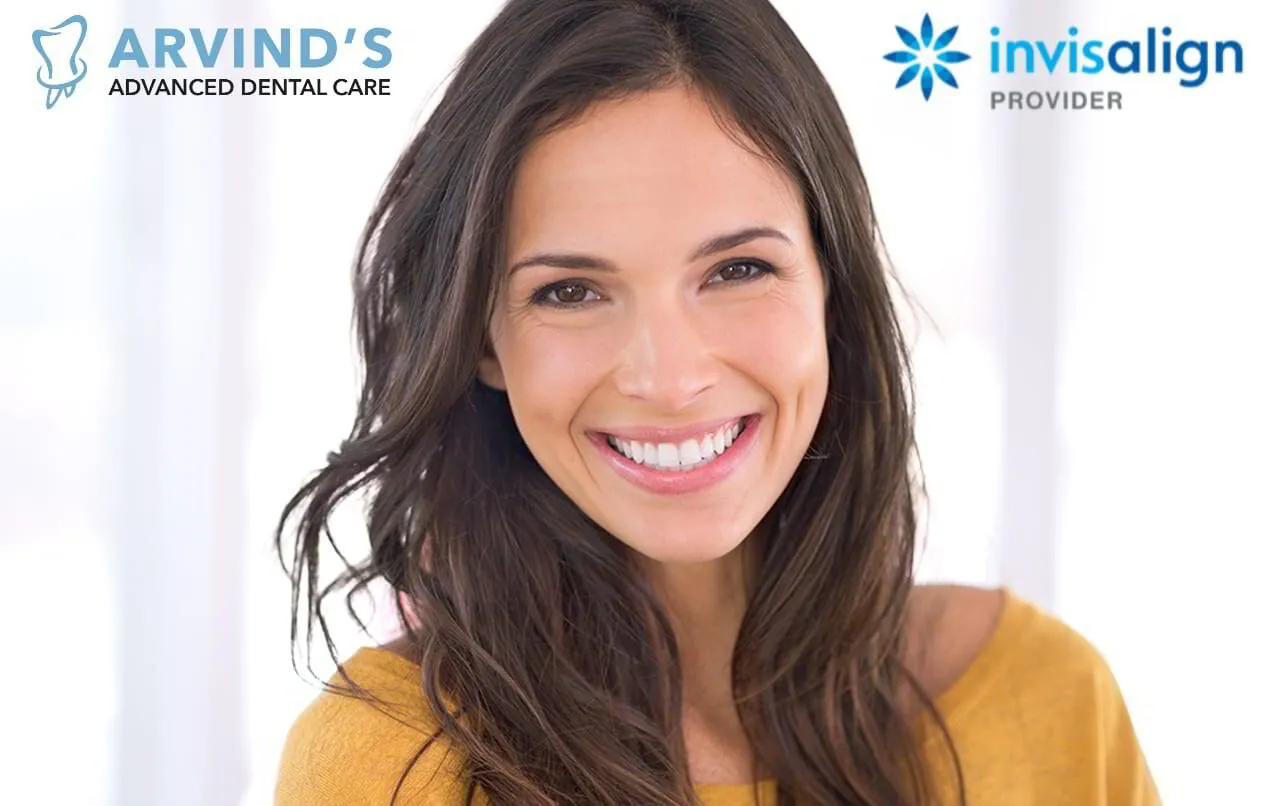 Smiling woman with straight, healthy-looking teeth representing Invisalign treatment