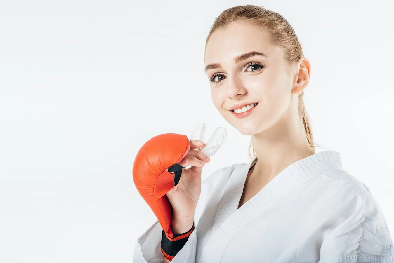 Woman wearing a clear dental aligner and boxing gloves