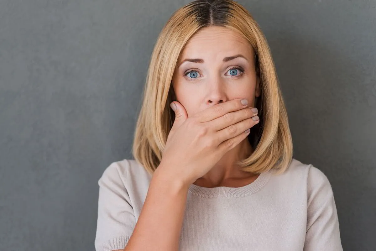 Woman covering her mouth due to bad breath or oral health concern